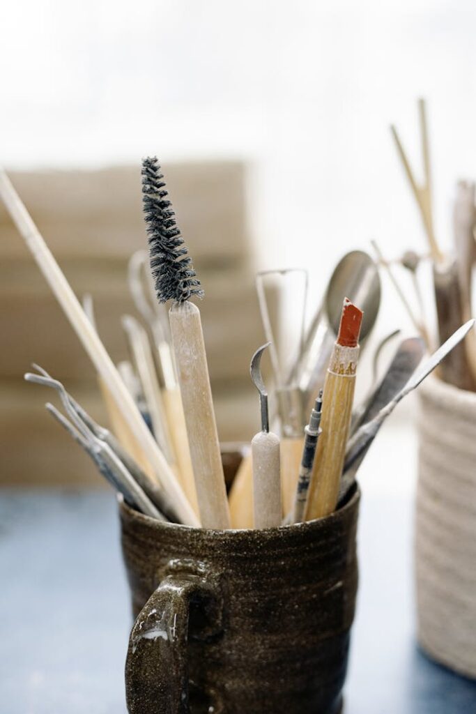 pexels-photo-6611465 A collection of assorted art tools in a ceramic mug, ideal for creative projects.